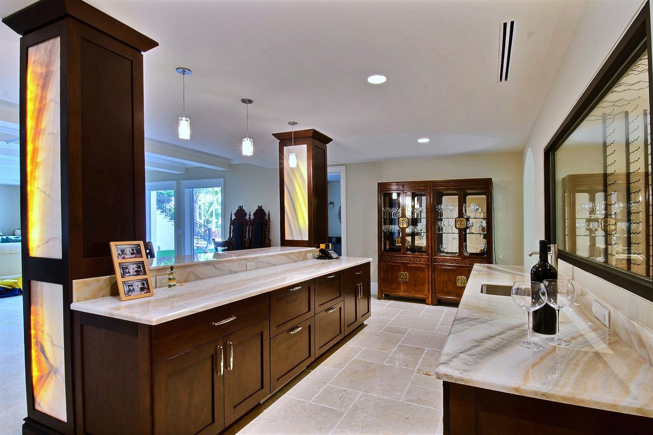 Wet bar and lounge with large-format natural stone tile flooring