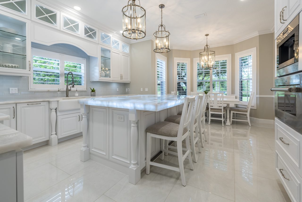 Traditional white kitchen with backlit island and bay-window dining area