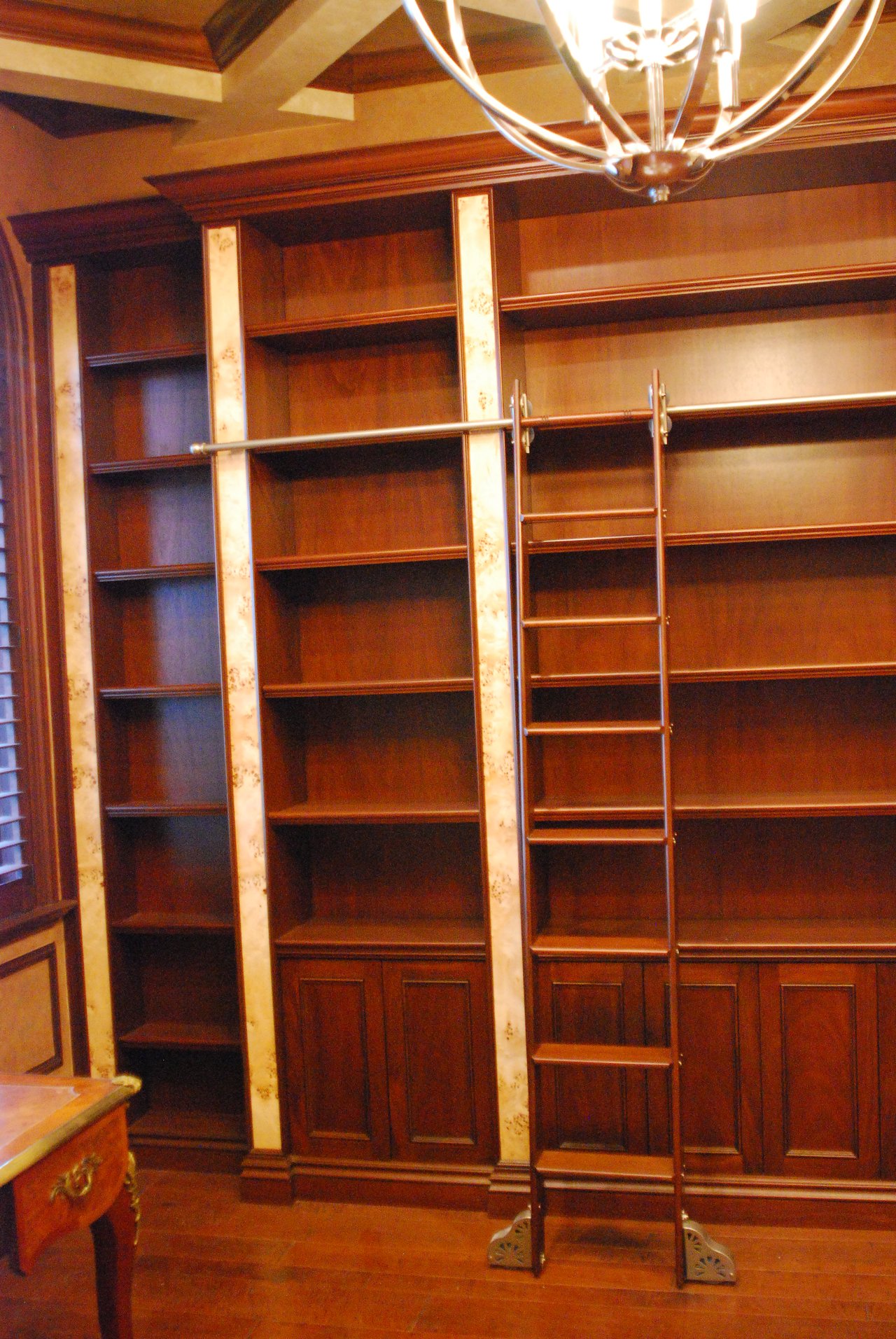 Custom built-in library millwork with a rolling ladder, fabricated by Wolf in the Woods