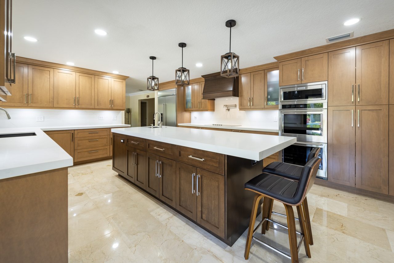 Maple shaker cabinetry with a walnut island, quartz countertops and built-in wall ovens
