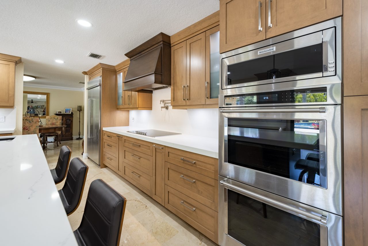 Built-in wall ovens and cooktop integrated into a maple cabinet run