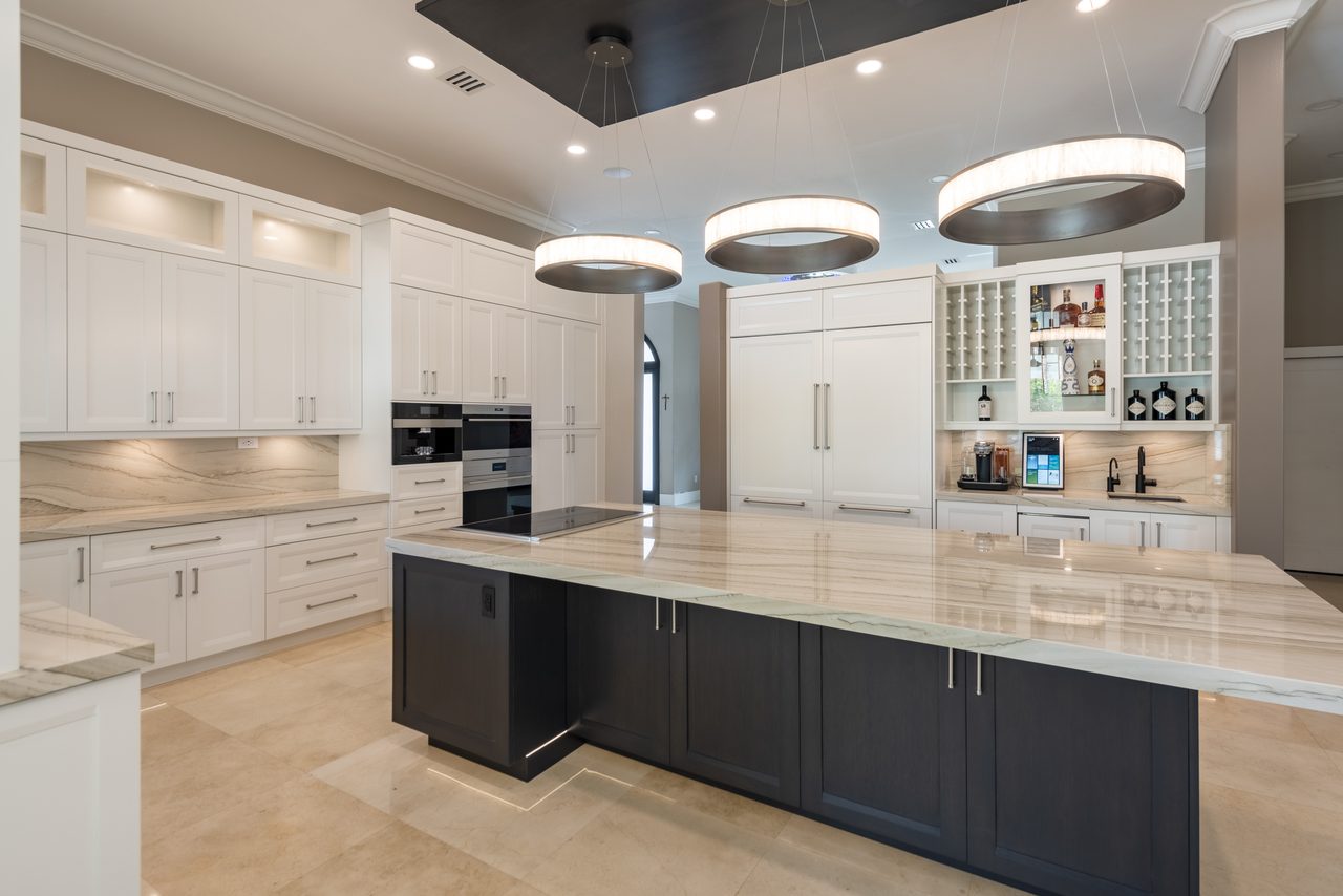 White inset cabinetry, quartzite waterfall island and integrated panel-ready refrigeration