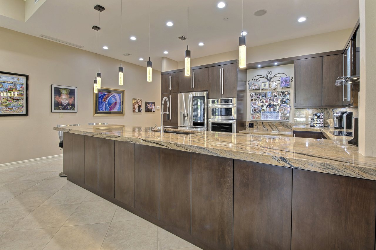 Cooktop and range wall set into custom cabinetry with stone countertops