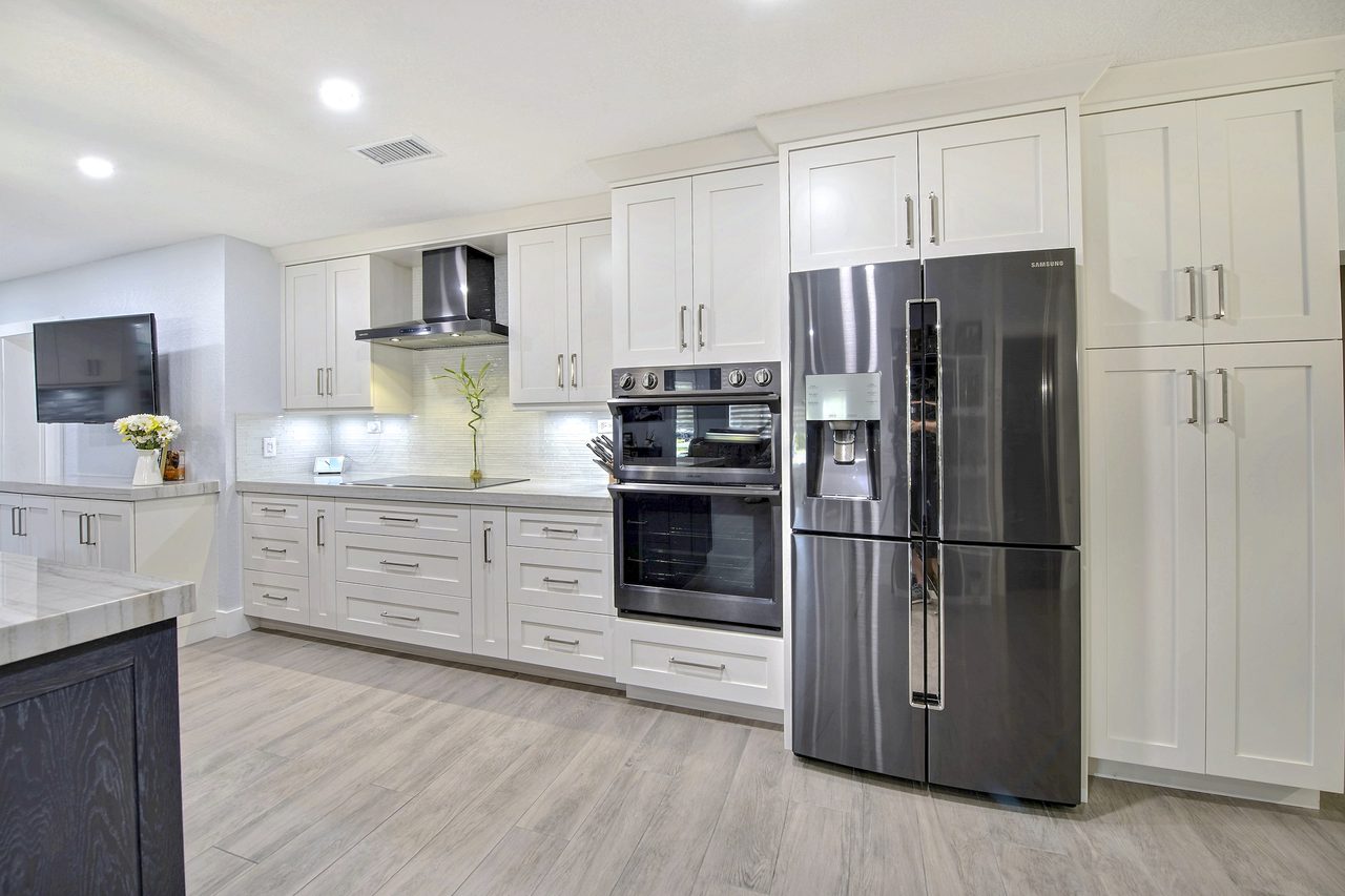 Full-height refrigerator integrated into a run of shaker cabinetry