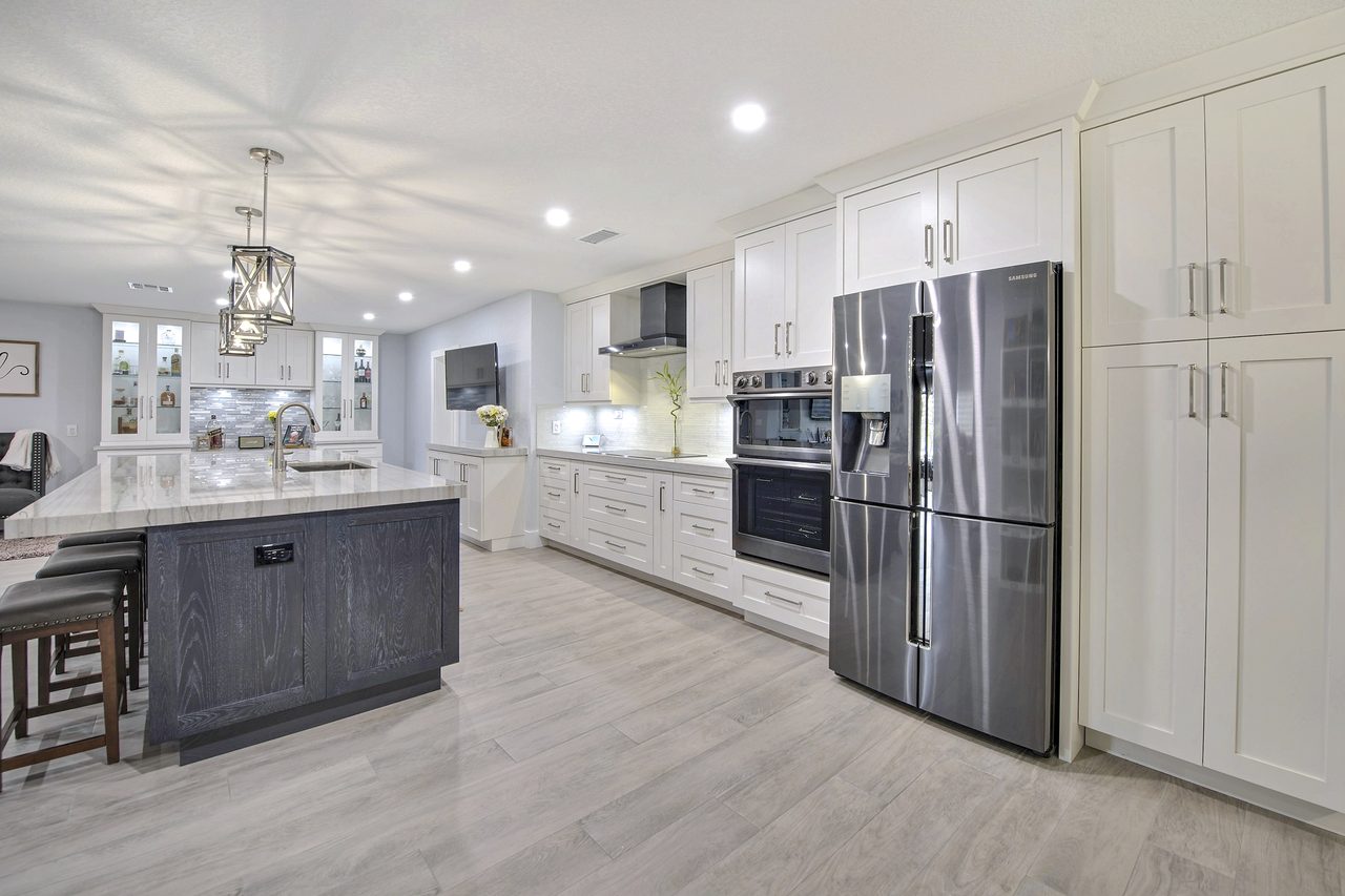 Transitional kitchen with shaker cabinetry, gray-wash oak island and wood-look plank flooring